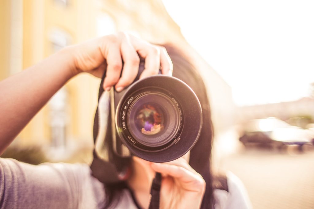 woman in gray shirt taking a photo shoot during day time